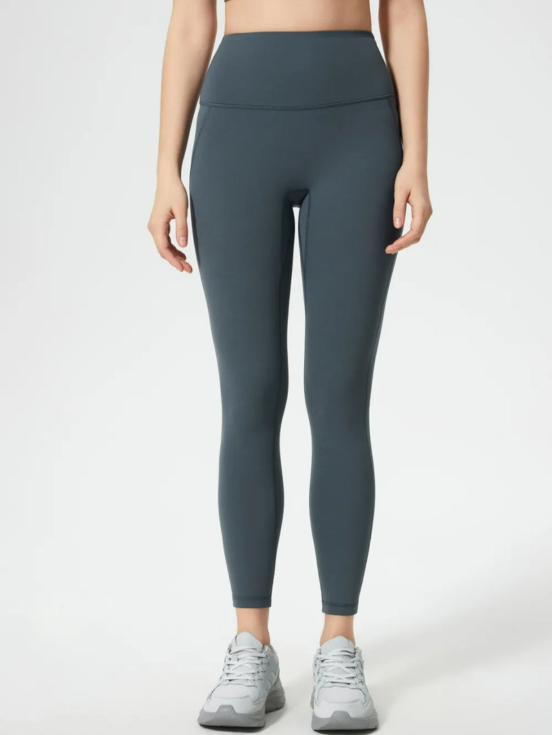 Person wearing dark gray leggings on a white background