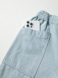 Light blue striped pants with a smartphone in the pocket on a light gray background