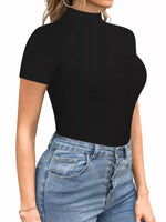 Person wearing a black turtleneck top and blue jeans on a white background