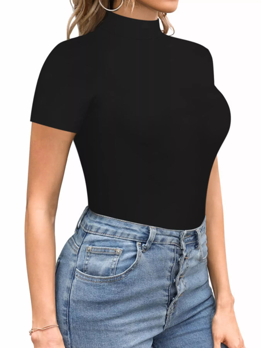 Person wearing a black turtleneck top and blue jeans on a white background