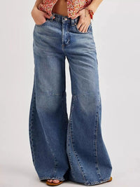 Wide-leg jeans worn by a person on a plain background