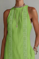 Green sleeveless dress with lace detailing on a plain background