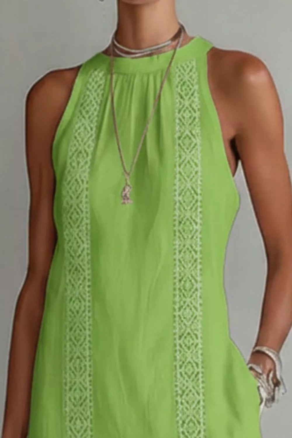 Green sleeveless dress with lace detailing on a plain background