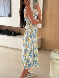 Woman taking a mirror selfie wearing a floral dress in a room.