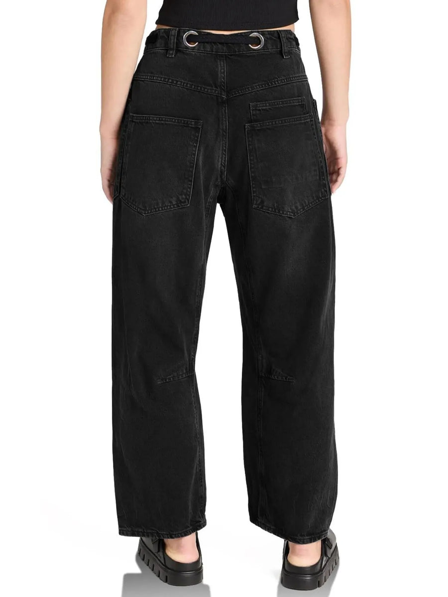 Person wearing black wide-leg jeans on a white background