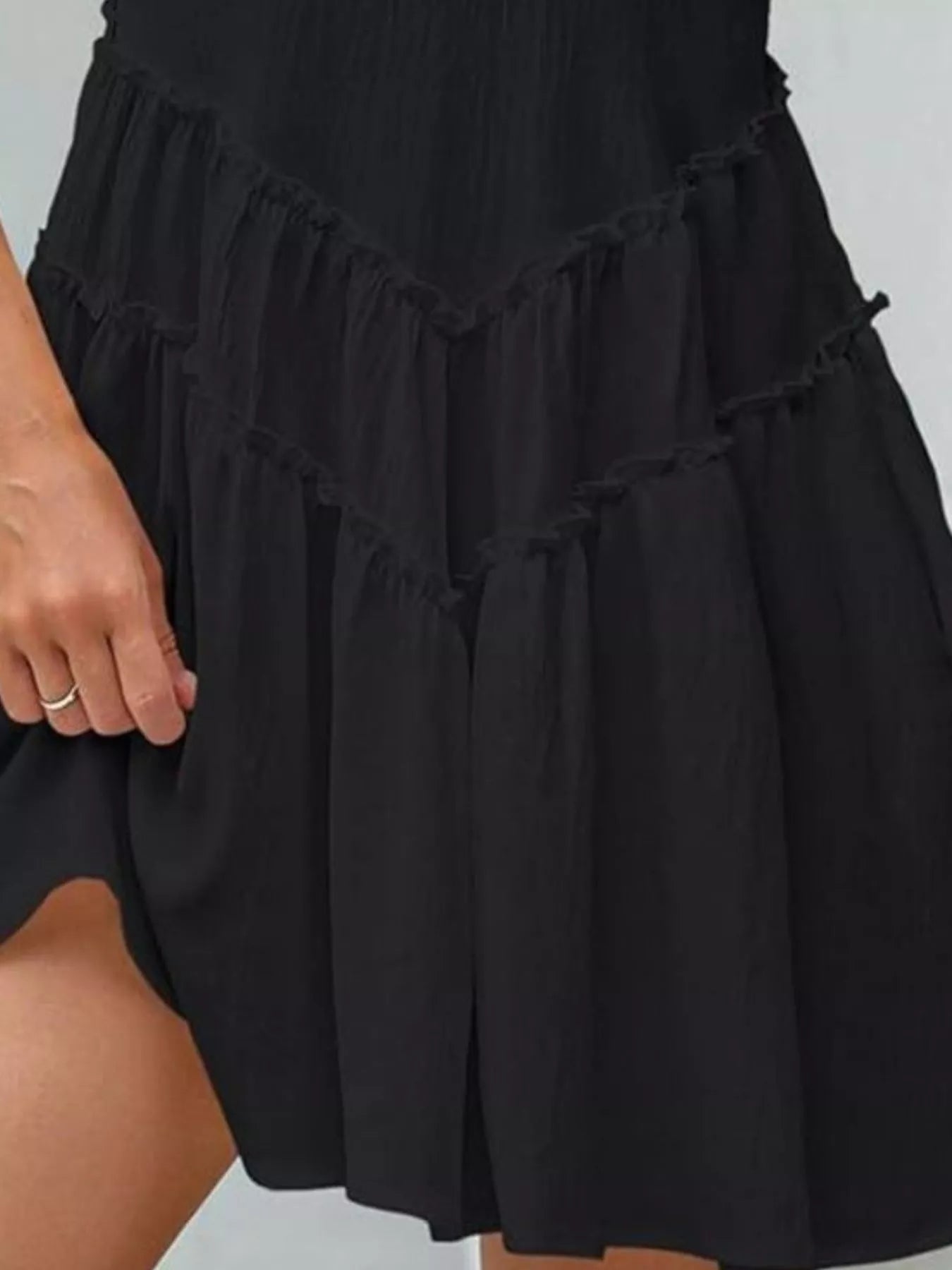 Black tiered dress on a plain background