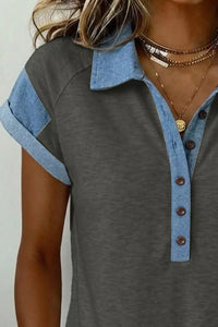 Gray shirt with blue collar and cuffs worn by a person on a white background