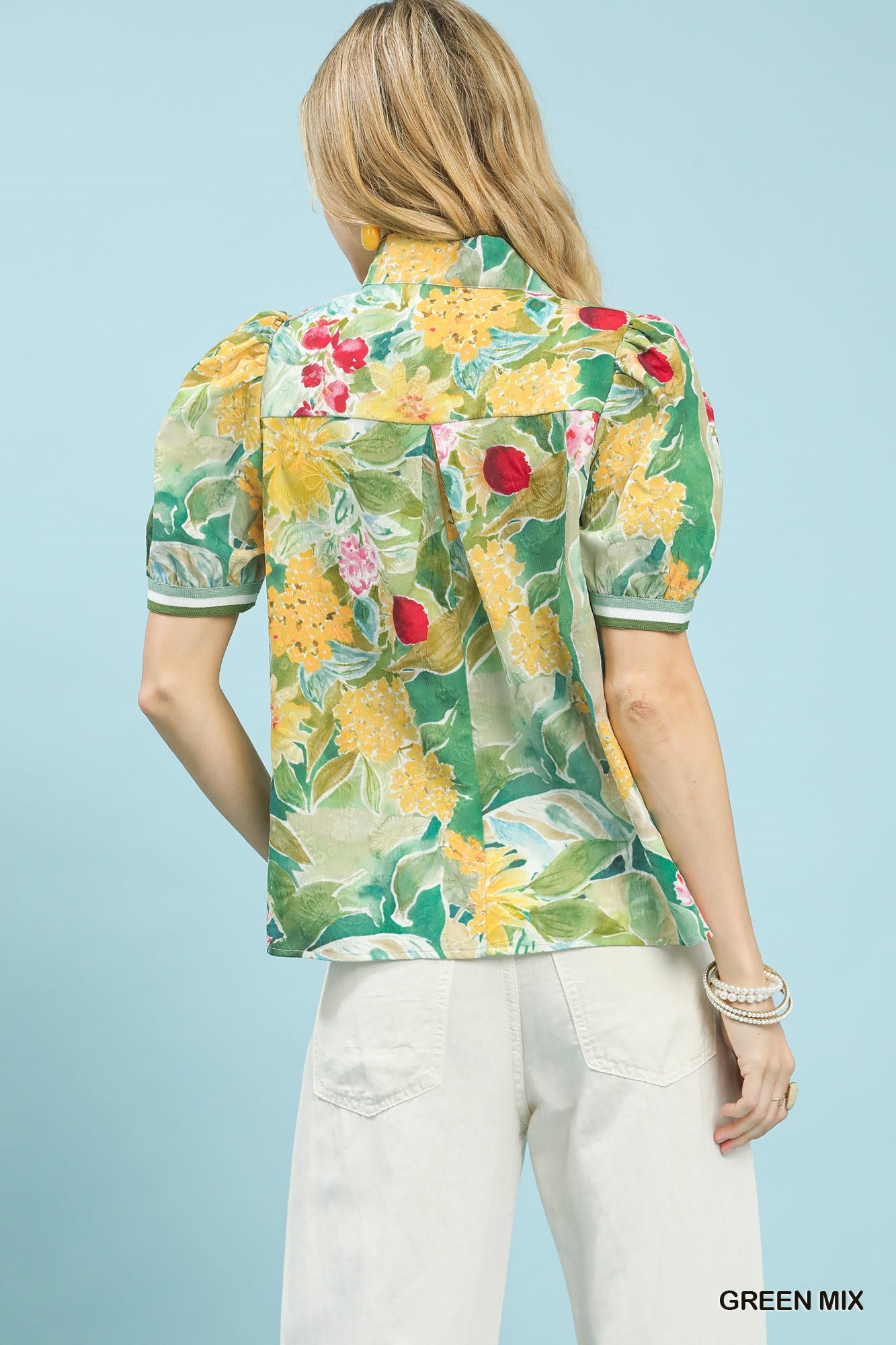 Woman wearing a colorful floral blouse with a light blue background