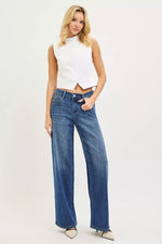 Woman wearing a white sleeveless top and blue jeans on a white background
