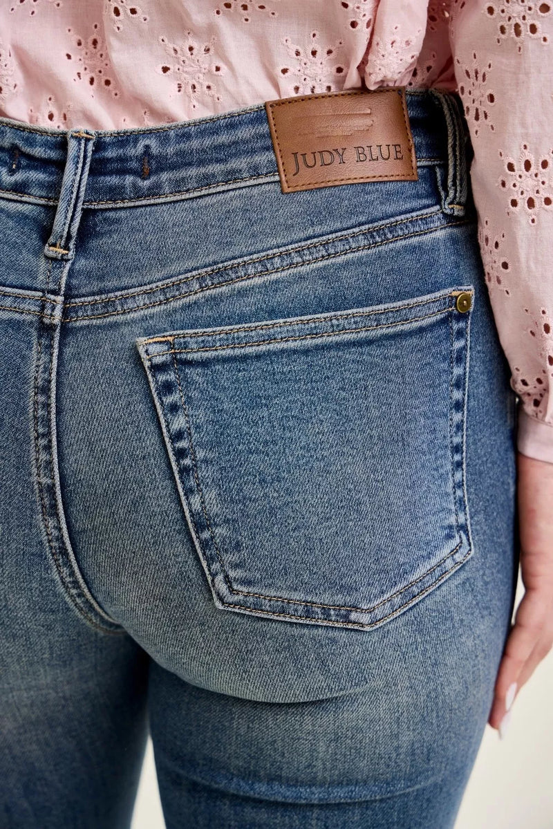 Close-up of blue jeans with a brand label on a light background