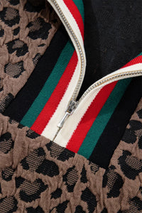 Close-up of a jacket with leopard print, red, green, and white zipper details.
