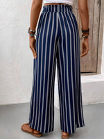 Navy and white striped pants worn by a person against a neutral background
