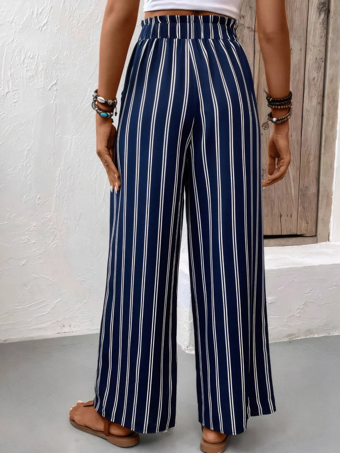 Navy and white striped pants worn by a person against a neutral background