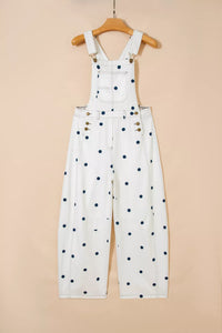 White denim overalls with black polka dots on a beige background