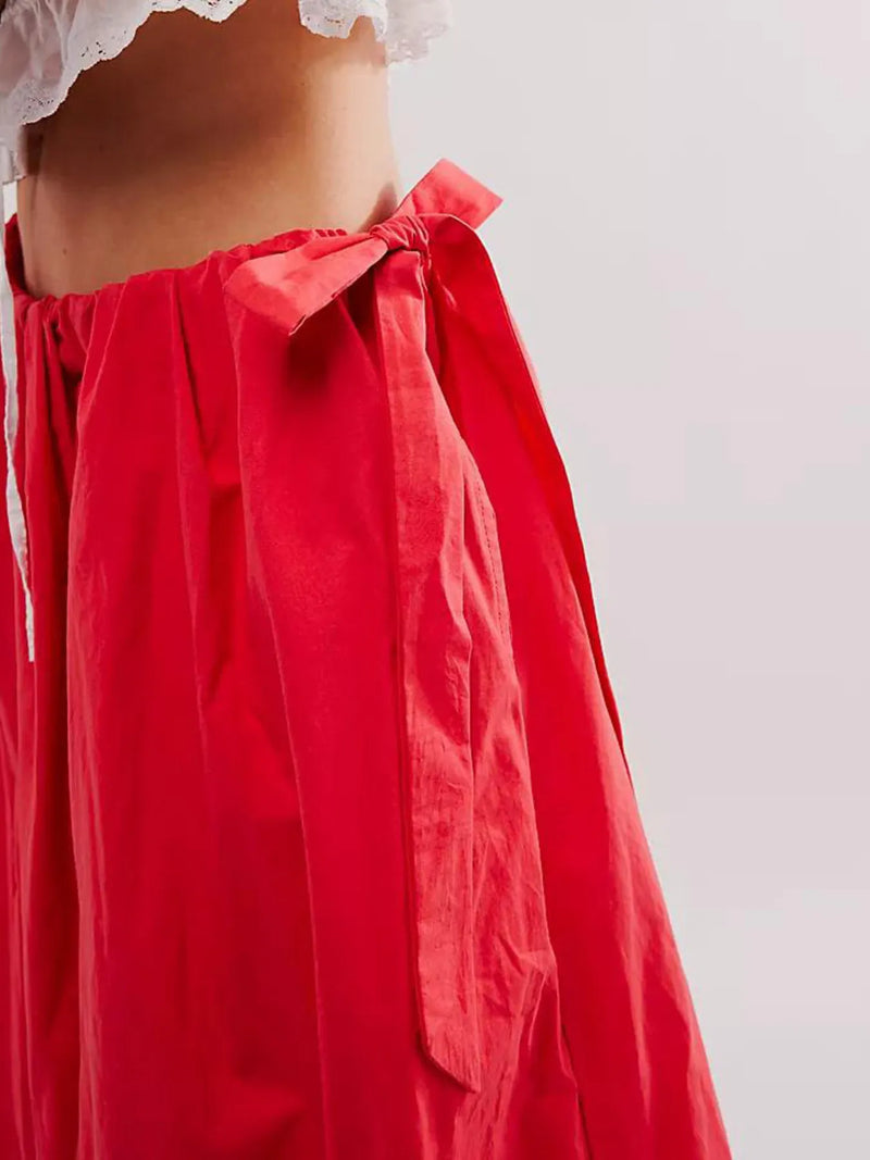 Red skirt with a white lace top on a plain background