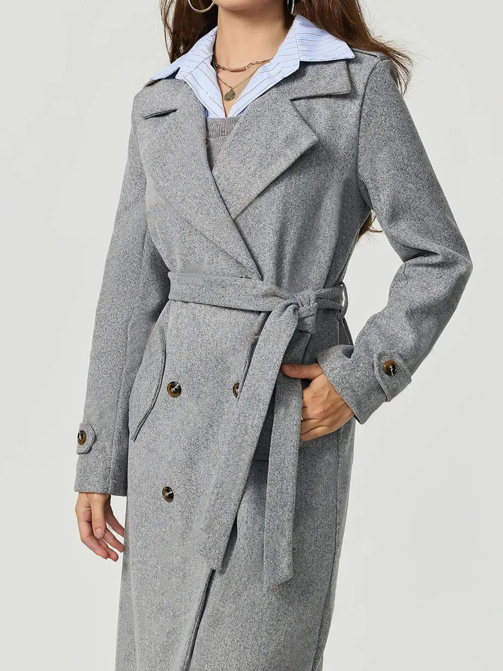 Gray trench coat worn by a person on a white background