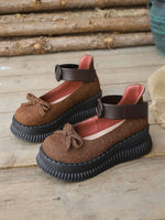 Brown sandals with black soles on a wooden surface