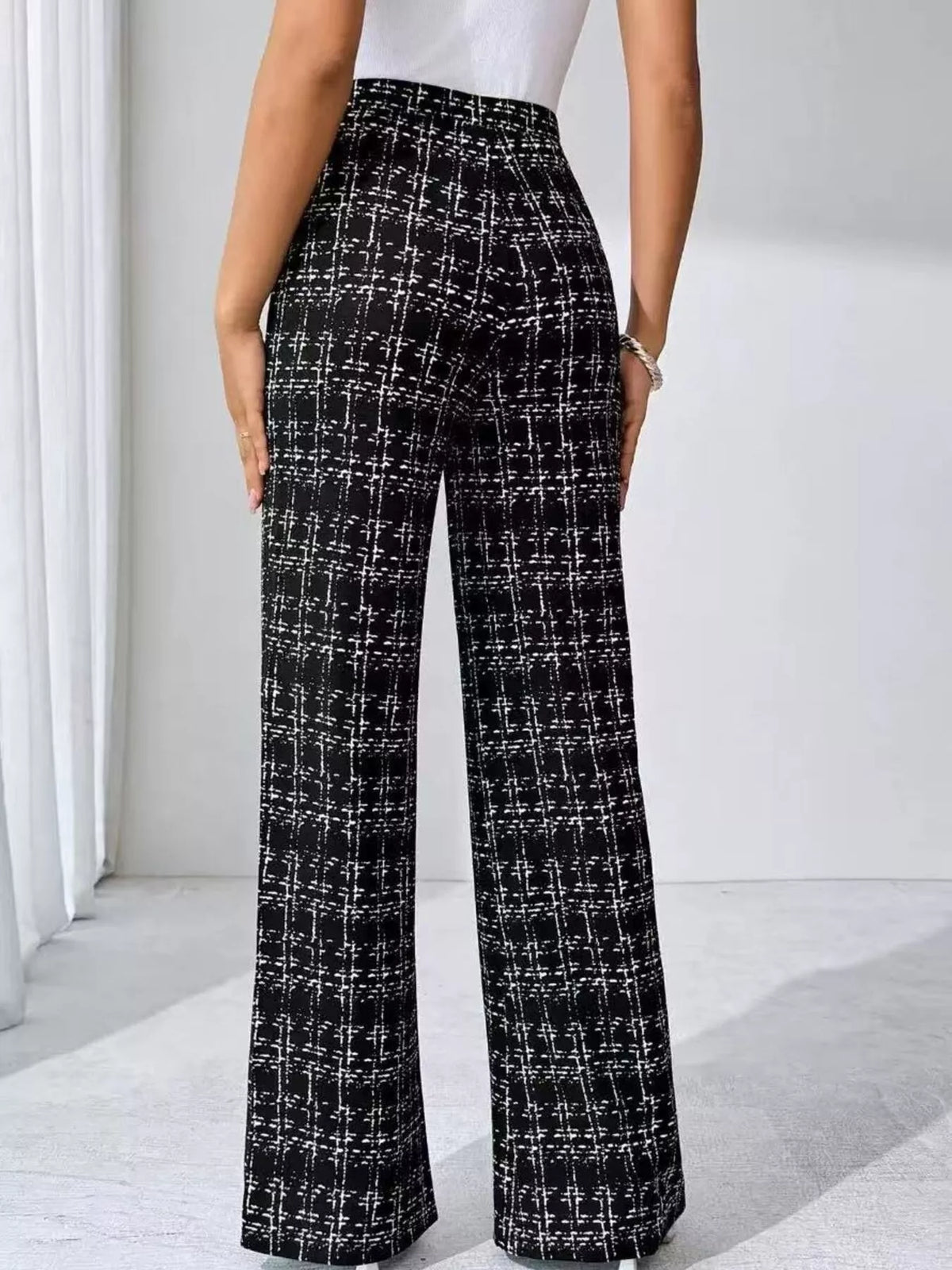 Black and white plaid pants worn by a person on a white background