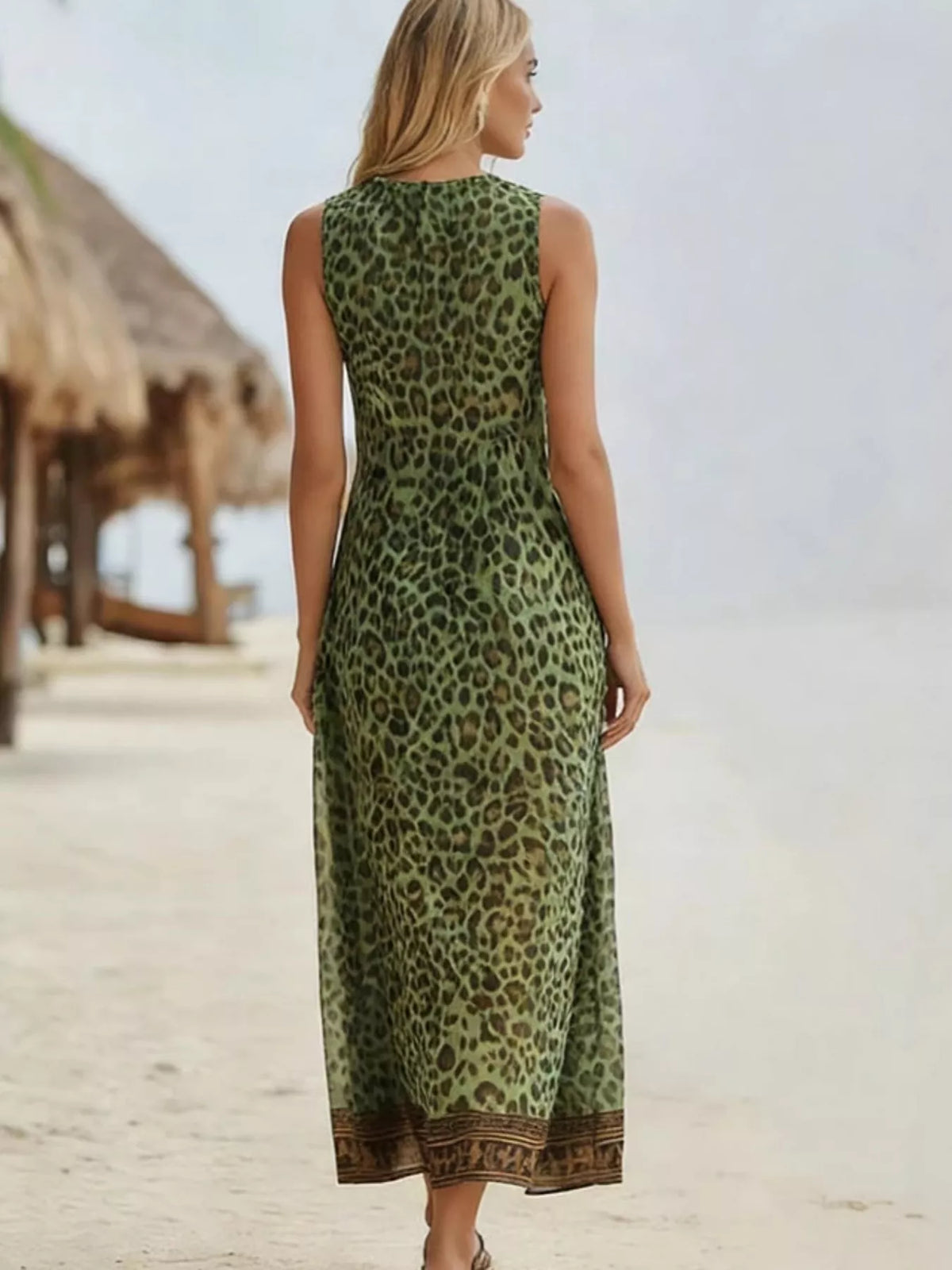 Woman wearing a green leopard print dress on a beach.