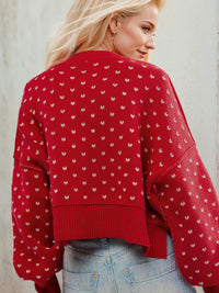 Woman wearing a red sweater with white patterns against a light background