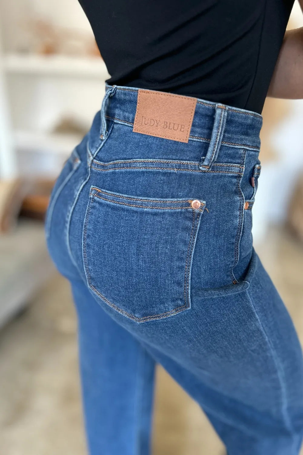 Blue jeans with a brand label on a blurred indoor background