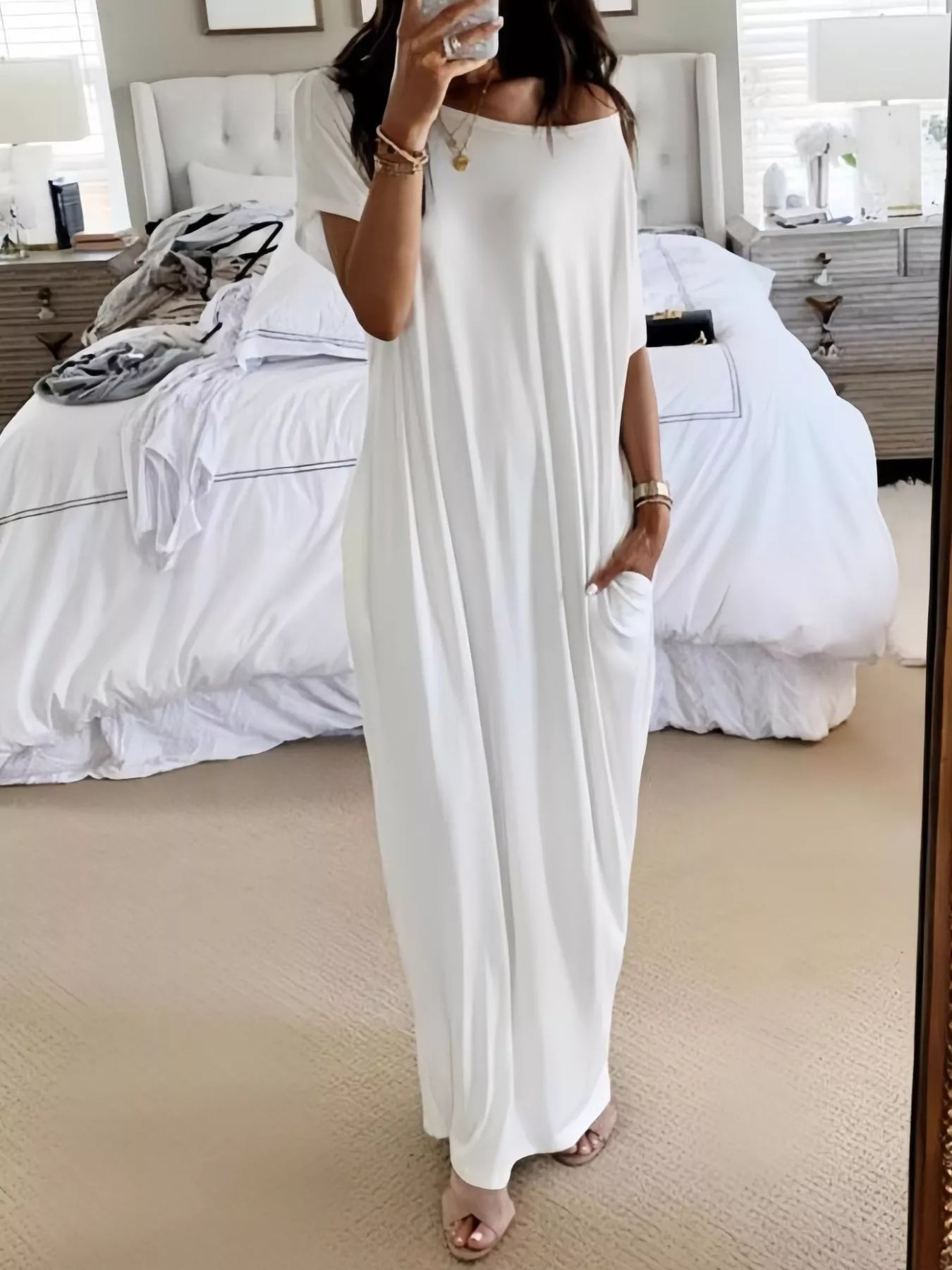 Woman wearing a white dress in a bedroom setting