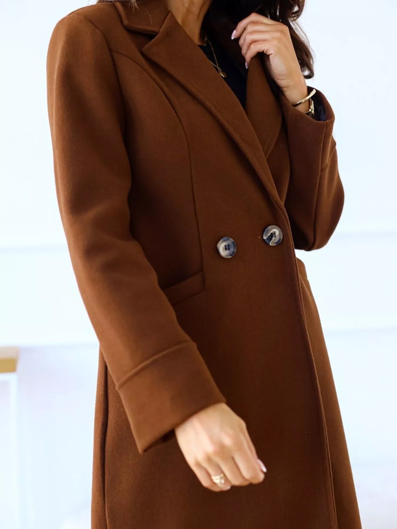 Brown coat worn by a person on a white background