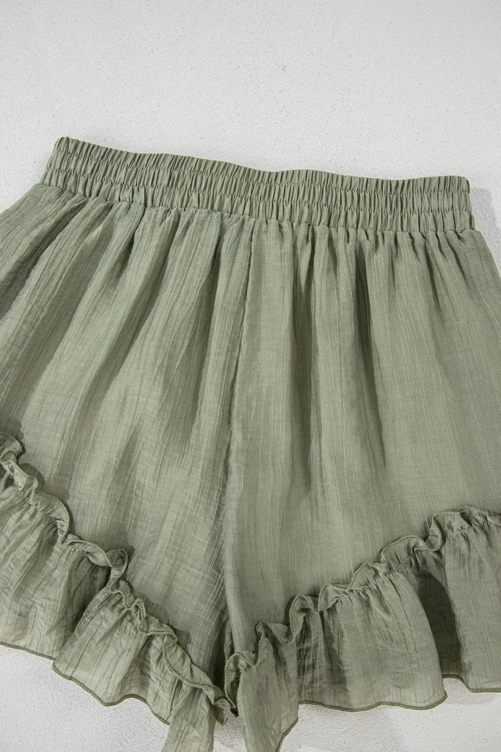 Green ruffled shorts on a white background