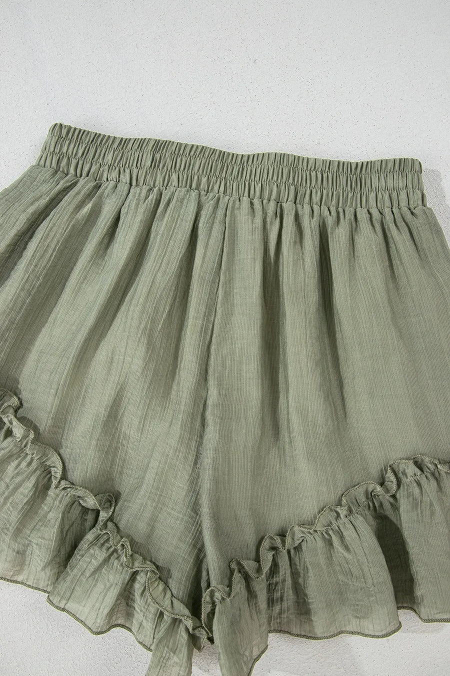 Green ruffled shorts on a white background