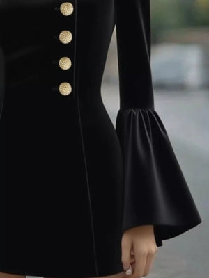 Black dress with gold buttons on a blurred background