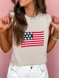 Woman wearing a beige sleeveless top with an American flag design against a pink background