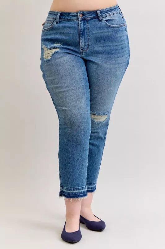Blue jeans with distressed details on a plain background