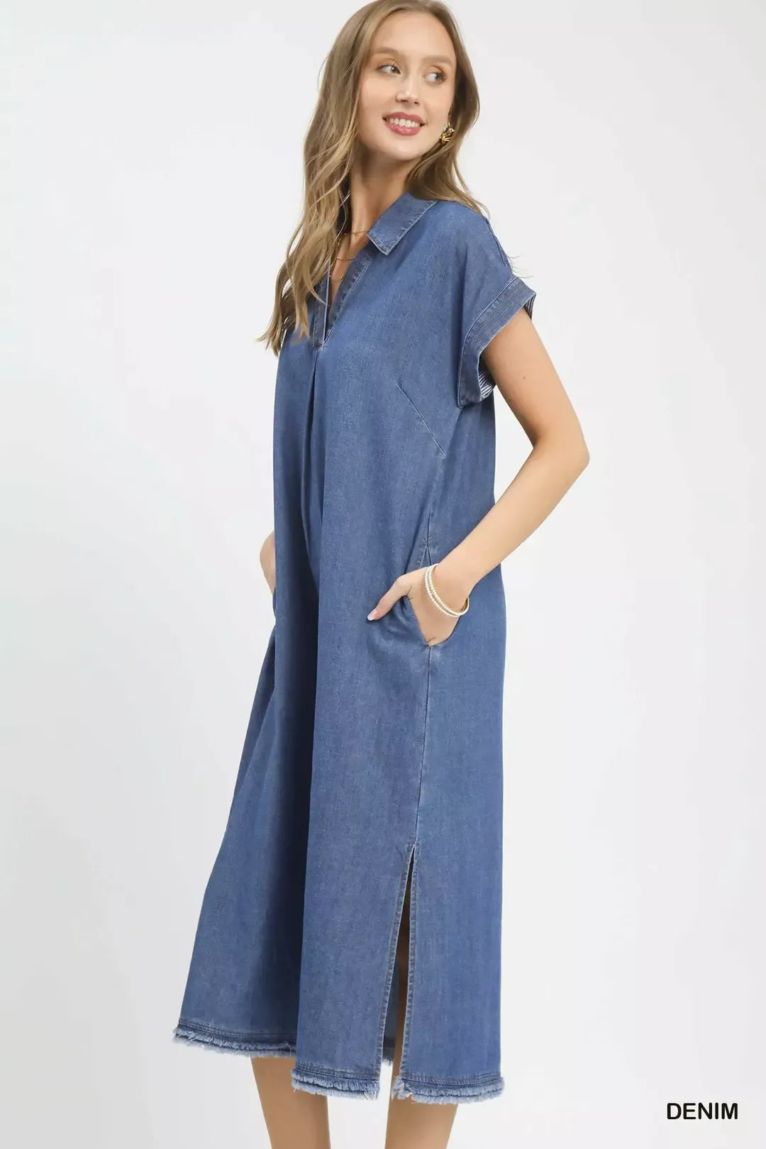 Woman wearing a long denim dress on a white background