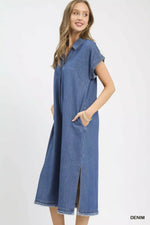 Woman wearing a long denim dress on a white background