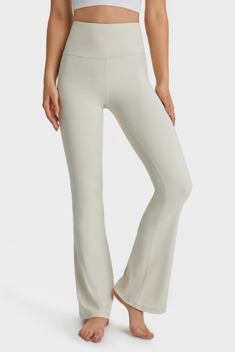 Person wearing light-colored yoga pants on a white background