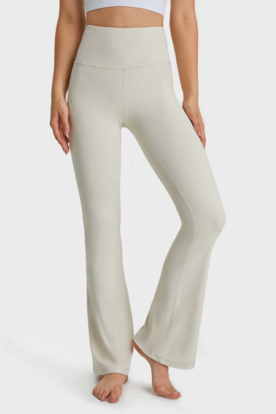 Person wearing light-colored yoga pants on a white background