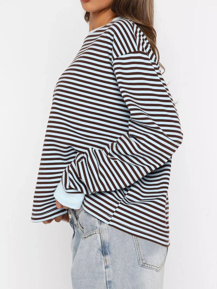 Person wearing a striped long-sleeve top with a plain background