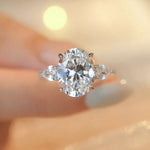 Diamond ring held by a hand with a blurred background