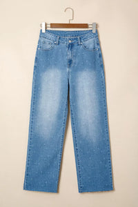 Blue jeans on a hanger against a beige background