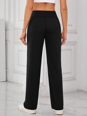 Person wearing black high-waisted pants in a minimalistic setting