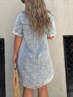 Person wearing a denim dress with a neutral background