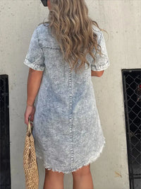 Person wearing a denim dress with a neutral background