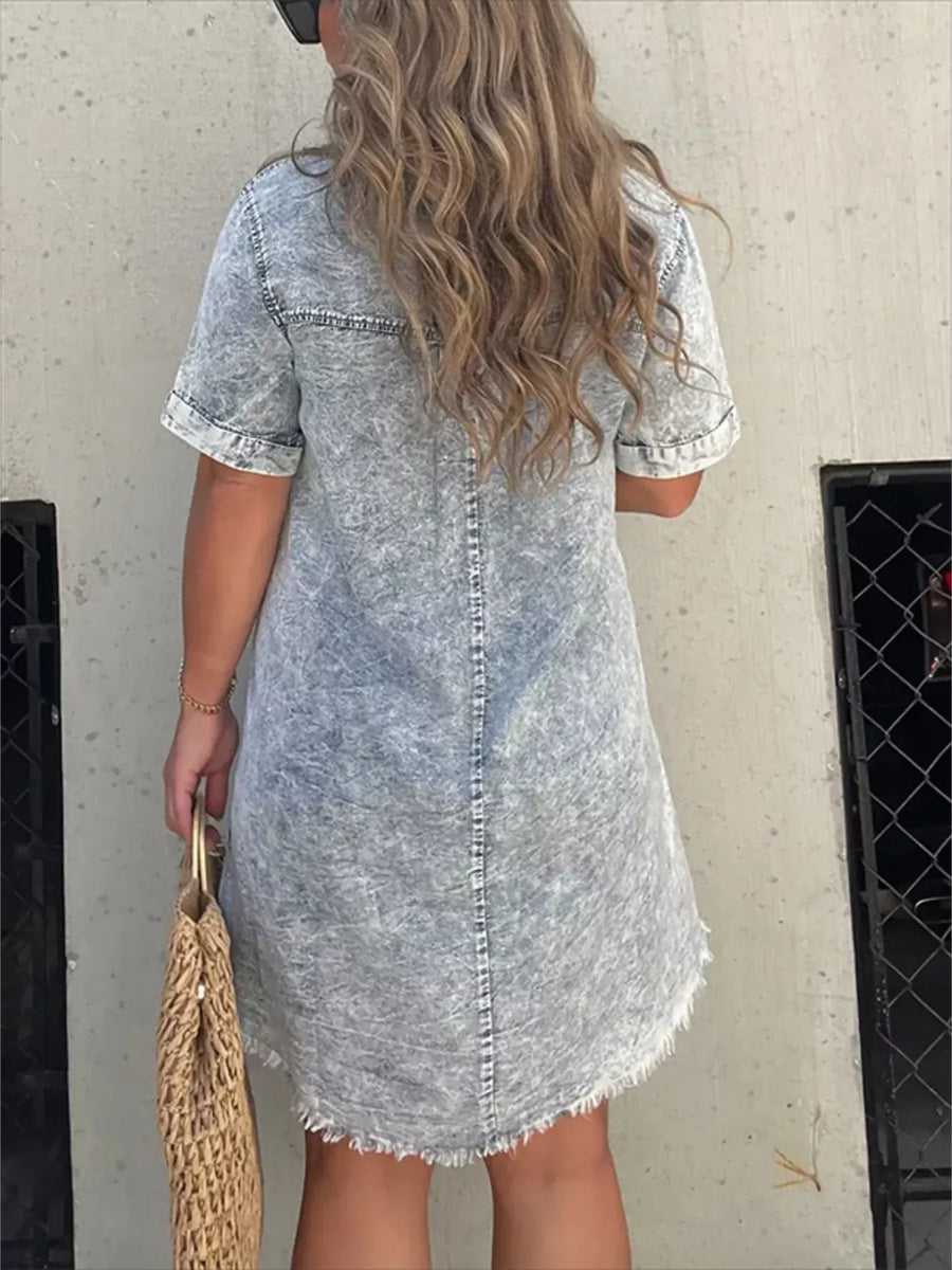 Person wearing a denim dress with a neutral background