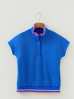 Blue shirt with pink trim on a hanger against a white background
