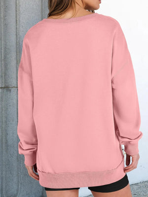 Person wearing a pink sweatshirt with a neutral background