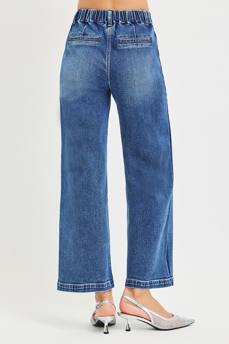 Blue jeans worn by a person on a white background