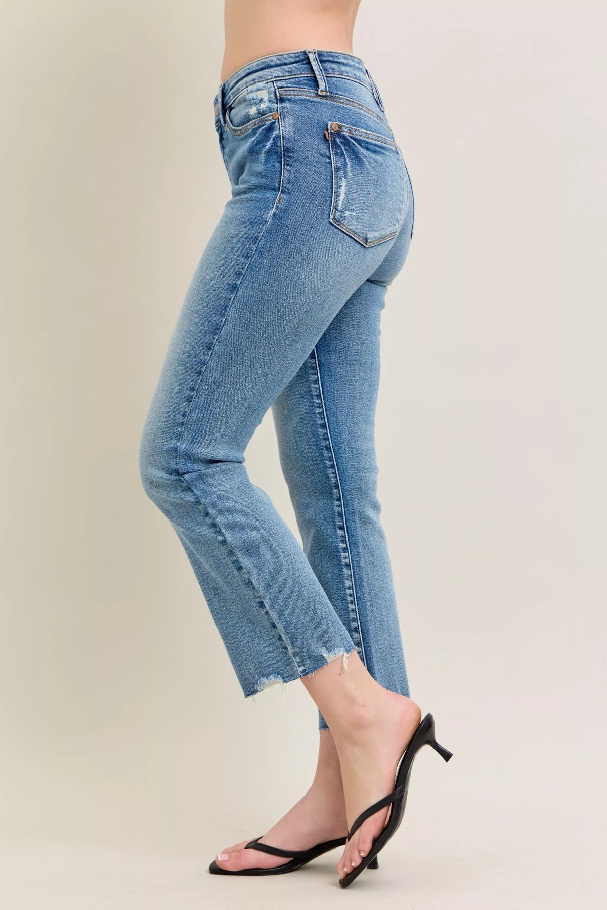 Light blue jeans worn by a person on a plain background