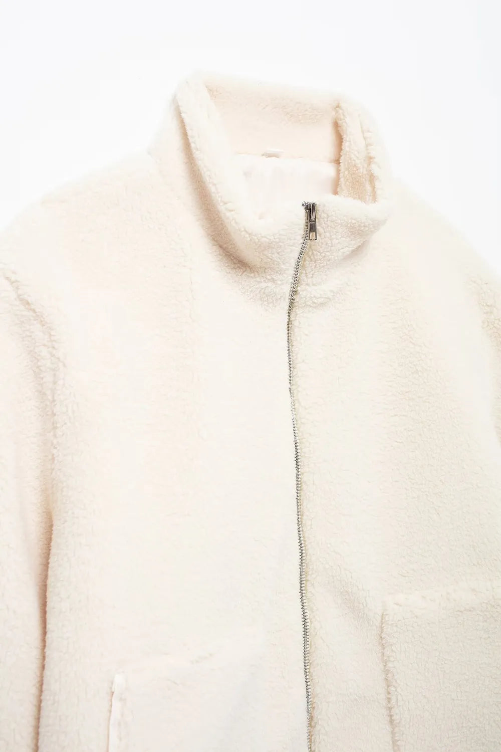 Close-up of a cream-colored puffer vest on a white background