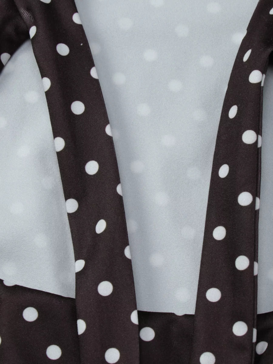 Close-up of a brown fabric with white polka dots on a light gray background