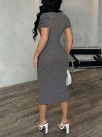 Woman wearing a black and white striped dress in an indoor setting.